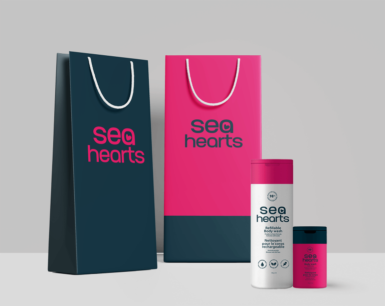 Product photography of ‘Sea Hearts' branded shopping bags and body wash bottles sitting in front of a white background.